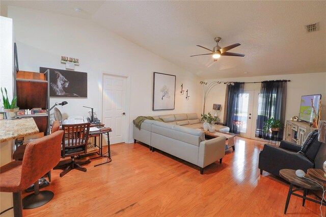 living room featuring vaulted ceiling, ceiling fan, and light hardwood / wood-style floors