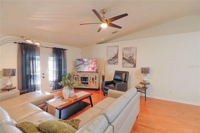 living room featuring hardwood / wood-style flooring, lofted ceiling, french doors, and ceiling fan