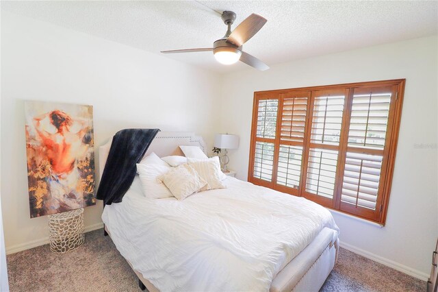 carpeted bedroom with a textured ceiling and ceiling fan