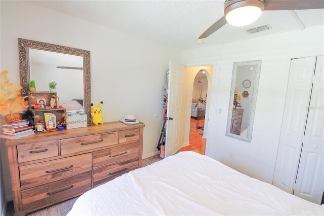 carpeted bedroom featuring a closet and ceiling fan