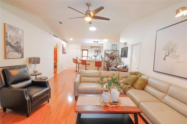 living room with vaulted ceiling, light hardwood / wood-style flooring, and ceiling fan