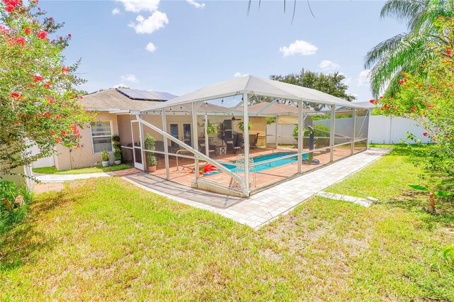 view of yard with a patio, glass enclosure, and a fenced in pool