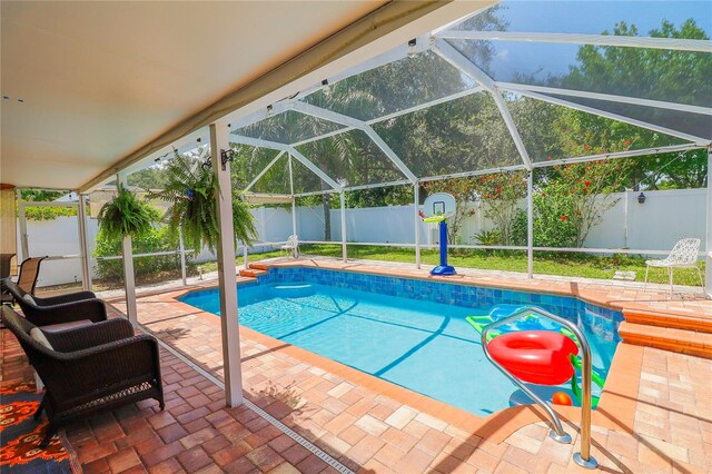 view of swimming pool featuring a patio and a lanai