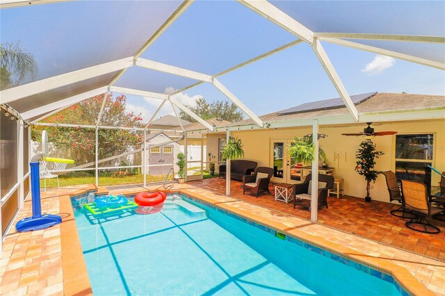 view of pool featuring ceiling fan, a patio area, and a lanai