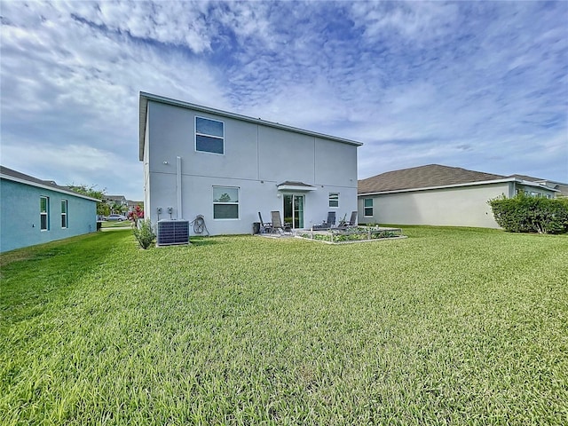 back of house featuring central AC and a yard