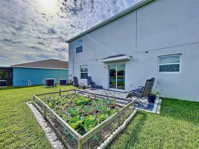 back of house with central AC, a yard, and a patio area