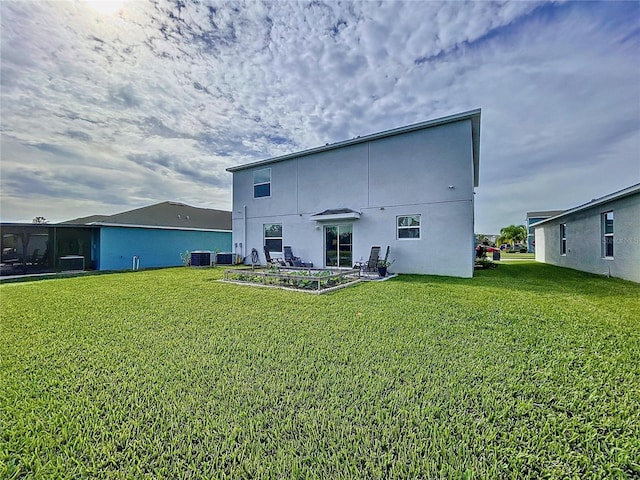 rear view of property featuring a lawn and central AC