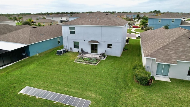 rear view of house featuring central air condition unit, a patio area, and a yard