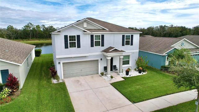 view of front of house featuring a garage, a water view, and a front lawn