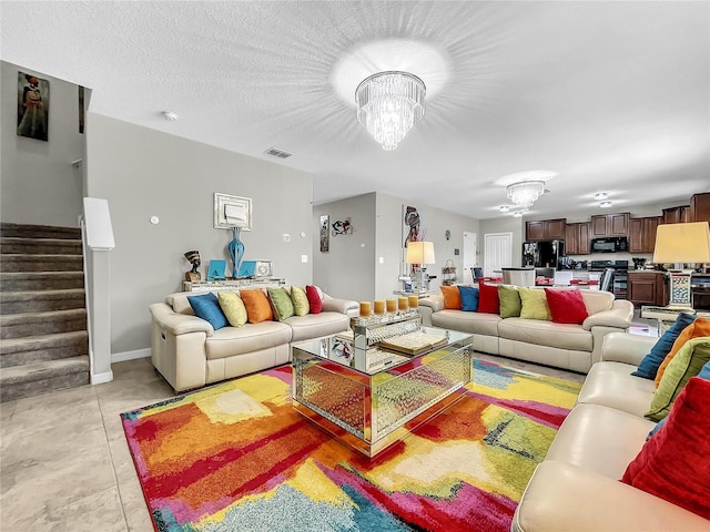 tiled living room featuring a notable chandelier and a textured ceiling