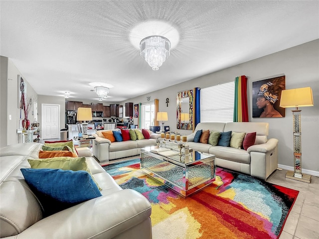 tiled living room featuring a chandelier and a textured ceiling