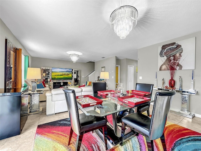 tiled dining room with an inviting chandelier