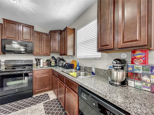 kitchen featuring light stone counters, black appliances, a textured ceiling, sink, and light tile patterned flooring