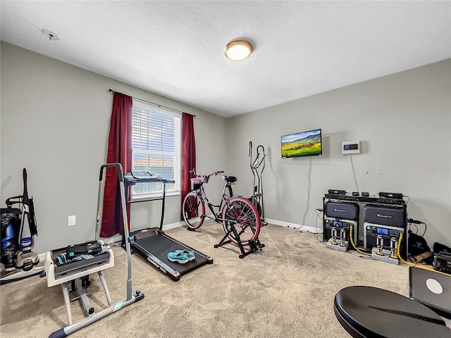 workout area with carpet floors and a textured ceiling