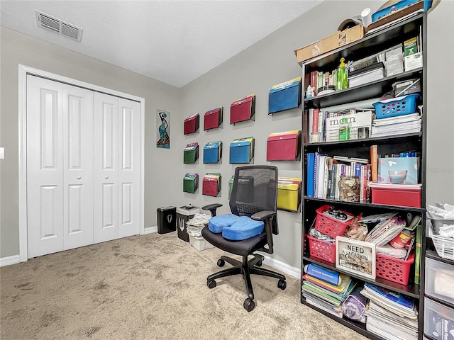 carpeted office featuring a textured ceiling