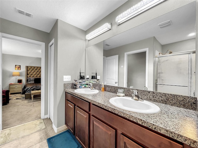 bathroom with vanity, tile patterned flooring, a textured ceiling, and an enclosed shower