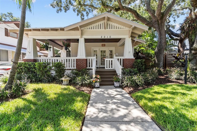 view of front of home featuring a front yard and french doors