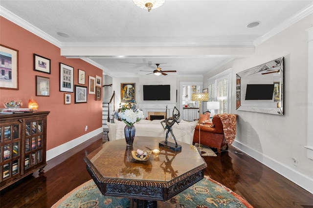 living room featuring beam ceiling, crown molding, dark wood-type flooring, and ceiling fan