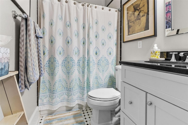 bathroom featuring vanity, curtained shower, and toilet