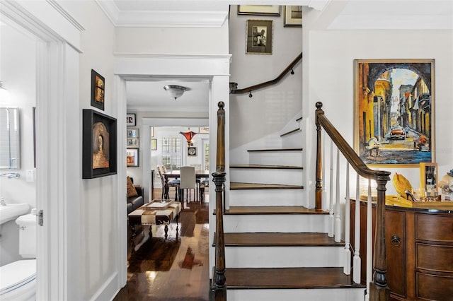 stairs featuring hardwood / wood-style flooring and ornamental molding