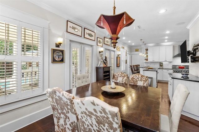 dining space with ornamental molding, dark hardwood / wood-style floors, and sink