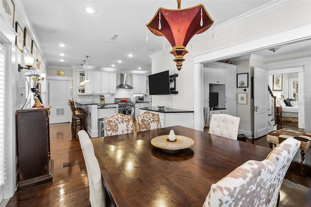 dining room featuring sink, crown molding, and dark hardwood / wood-style floors