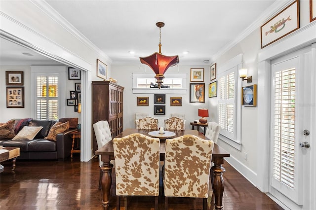 dining area featuring crown molding, a healthy amount of sunlight, and dark hardwood / wood-style flooring