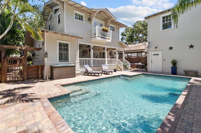 back of property featuring ceiling fan, a balcony, and a patio