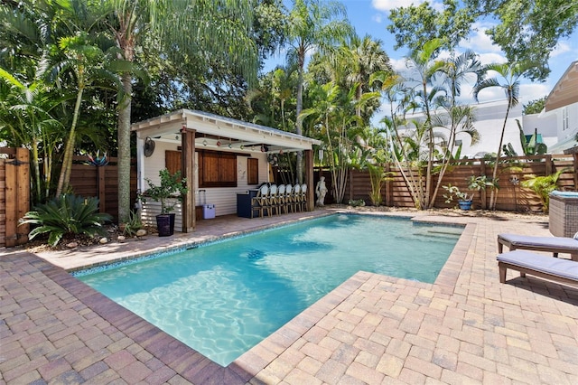 view of swimming pool with an outbuilding, a patio area, and exterior bar