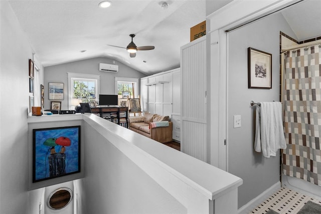 hall with vaulted ceiling and a wall unit AC