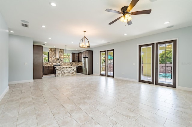 unfurnished living room featuring a healthy amount of sunlight, light tile patterned floors, and ceiling fan