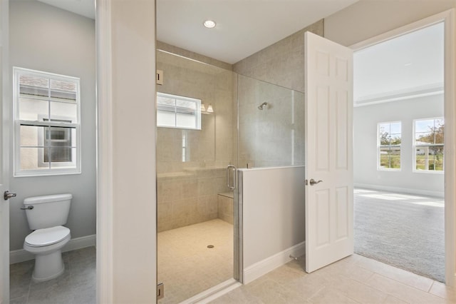 bathroom with toilet, tile patterned floors, and a shower with shower door