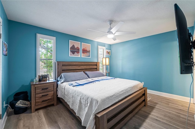 bedroom featuring hardwood / wood-style floors, a textured ceiling, and ceiling fan