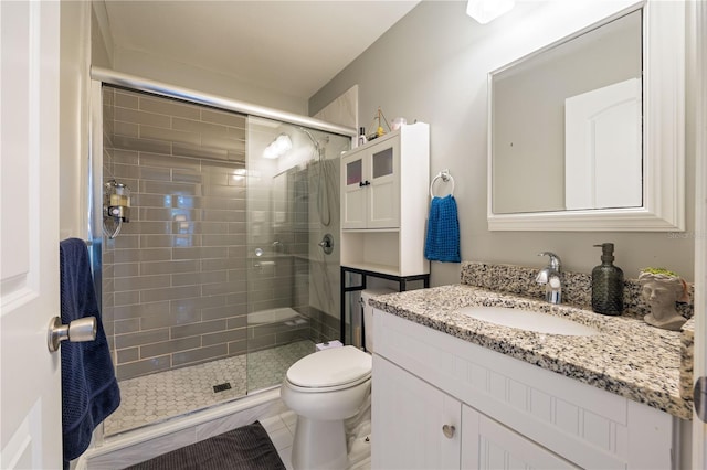 bathroom featuring tile patterned flooring, vanity, walk in shower, and toilet