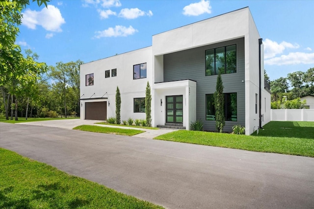 contemporary house featuring a garage and a front lawn