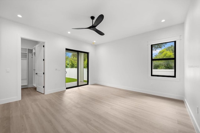 empty room with ceiling fan and light hardwood / wood-style floors