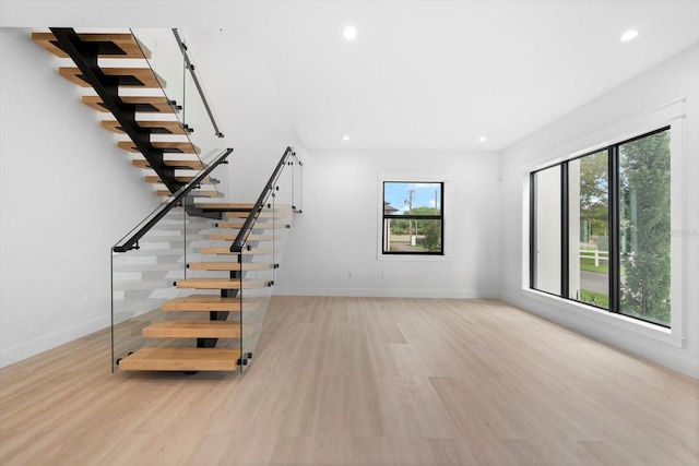 staircase with plenty of natural light and hardwood / wood-style floors