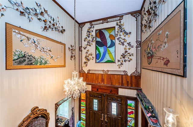 interior details featuring crown molding and an inviting chandelier