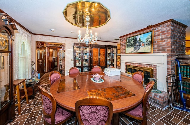 dining area with crown molding, an inviting chandelier, a brick fireplace, and a textured ceiling