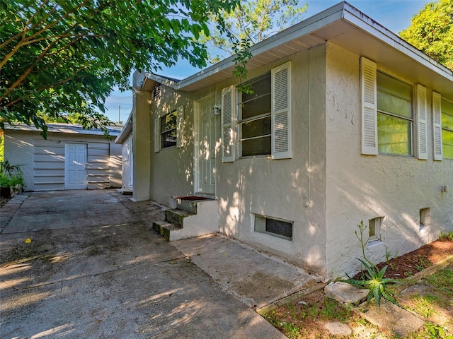 view of home's exterior with a storage shed and a patio