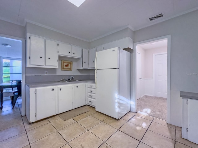 kitchen featuring white refrigerator, white cabinetry, sink, and ornamental molding