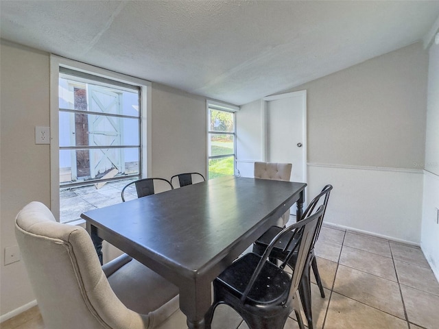 tiled dining area with a textured ceiling