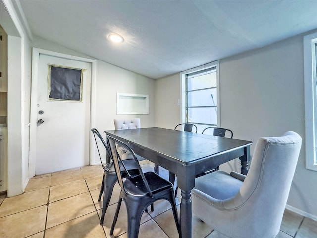 tiled dining area with lofted ceiling