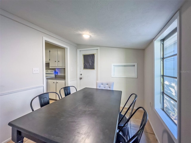 tiled dining room featuring a textured ceiling