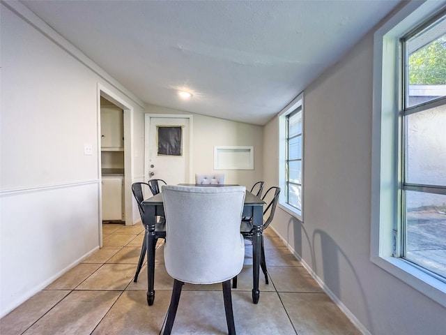 tiled dining area with lofted ceiling