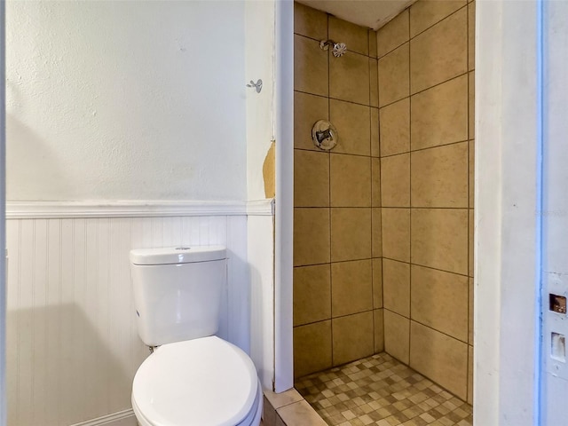 bathroom featuring a tile shower and toilet