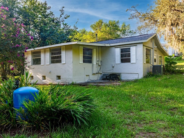 view of front of property with cooling unit and a front lawn