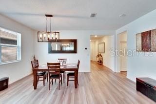 dining space featuring a chandelier and light hardwood / wood-style floors