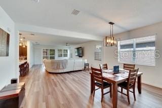 dining area with hardwood / wood-style floors and a notable chandelier