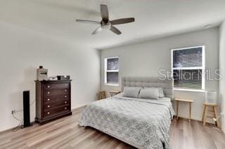 bedroom featuring multiple windows, ceiling fan, and light hardwood / wood-style floors